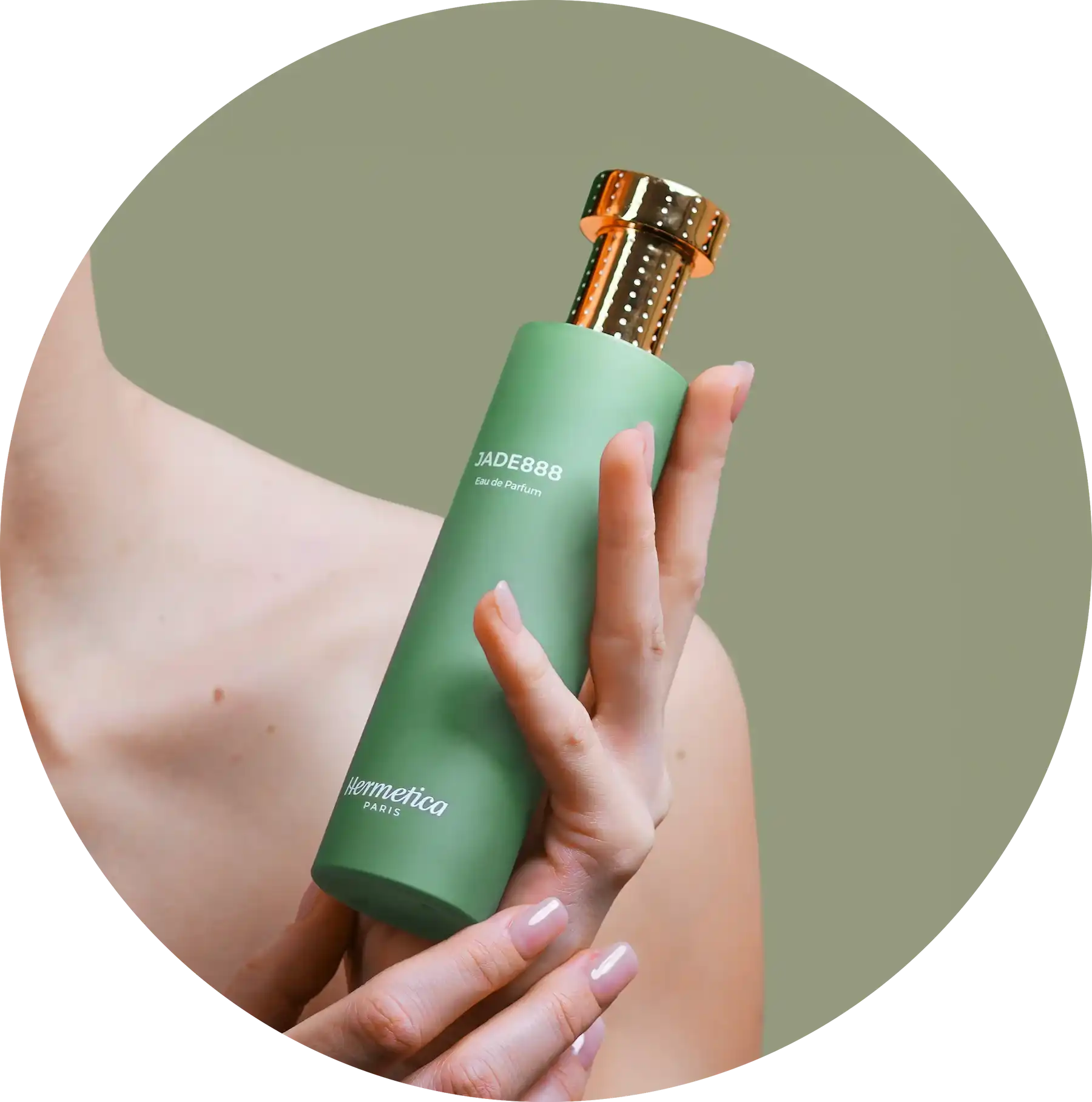 Mint green cosmetic bottle with a metallic gold cap being held by manicured hands.