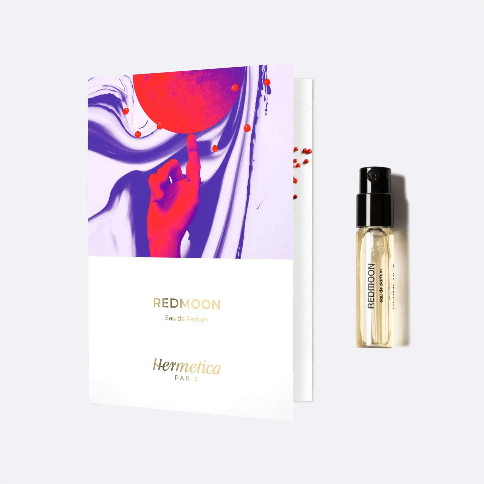 Perfume sample vial with a colorful red and purple artistic card.